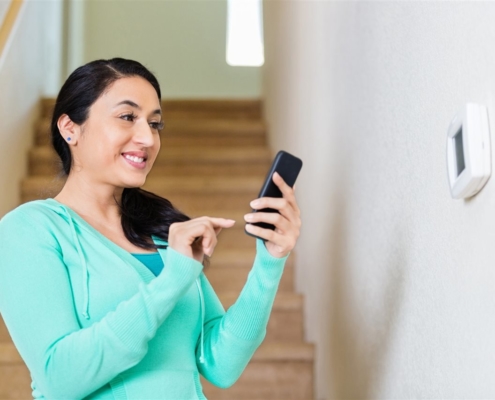 a woman smiling holding her phone | On Target Home Inspection | Home Security Orland Park