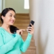 a woman smiling holding her phone | On Target Home Inspection | Home Security Orland Park